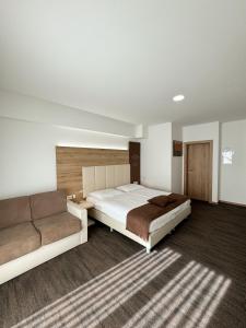 a bedroom with two beds and a couch at Hiša Aleš in Kranj