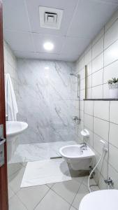 a white bathroom with a sink and a toilet at Two Continents Holiday Homes - Marvelous Marina Apartment in Dubai