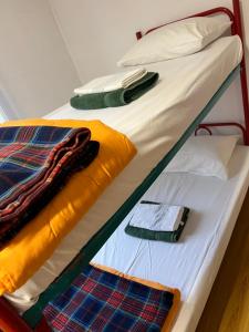2 Etagenbetten mit Handtüchern und einem Handy darauf in der Unterkunft B&B San Michele in Baia Mare