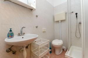 a bathroom with a sink and a toilet and a shower at Apartments Martino in Stomorska