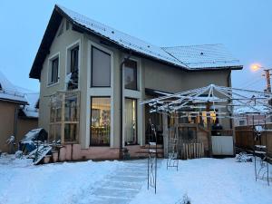 ein Haus mit Schnee auf dem Boden davor in der Unterkunft B&B San Michele in Baia Mare