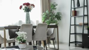 a dining room with a table and chairs with flowers at Two Continents Holiday Homes - Marvelous Marina Apartment in Dubai