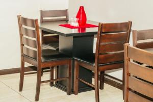 a dining room table and chairs with a red napkin at Heavenly Boutique Hotel in Johannesburg