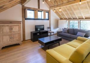 a living room with a couch and a tv at Huize D'Huys in Riemst