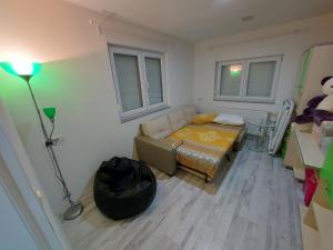 a room with a bed and a couch and a lamp at Apartman TT Stan na dan Trn Laktaši in Laktaši
