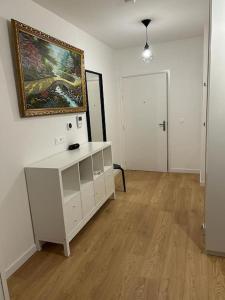 a room with a white cabinet and a painting on the wall at Studio moderne in Thoiry