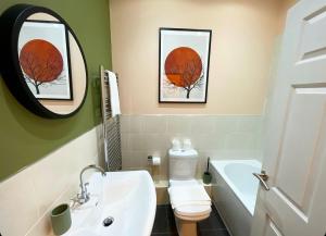a bathroom with a sink and a toilet and a mirror at Apartment 2 West County by Prestige Properties SA in Millom