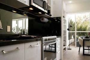 a kitchen with a stove top oven in a room at Design Apartment with Amazing Private Terrace in Mexico City