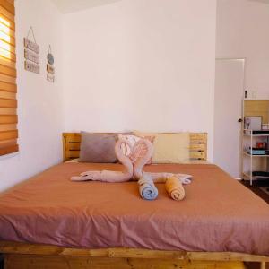 una cama con una serpiente de peluche puesta en ella en S&E-2 Tiny Guest House - Olango Island en Lapu Lapu City