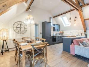a kitchen and living room with a wooden table and chairs at 2 Bed in Llangollen 86799 in Llangollen