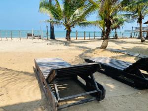 a picnic table on a beach with palm trees at Rainbow Village Cabanas in Arugam Bay