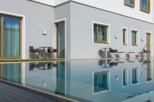 una piscina infinita con sillas y una mesa junto a un edificio en Gästehaus Klinglhuber, en Krems an der Donau