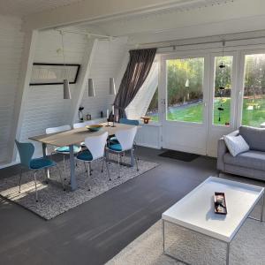 a living room with a table and chairs and a couch at Nurdachhaus Zeltdachhaus Damp in Damp