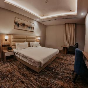 リヤドにあるSamt Inn Hotelの大きなベッドと椅子が備わるホテルルームです。