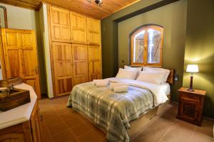 ein Schlafzimmer mit einem Bett mit zwei Handtüchern darauf in der Unterkunft Capris Rustic Ηouse with Mountain View in Archaia Feneos