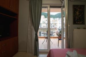 a bedroom with a bed and a balcony with a view at RIRIKA APARTMENT in Igoumenitsa