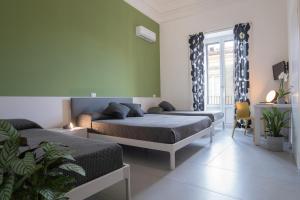 a bedroom with two beds and a window at Suite Inn Catania in Catania