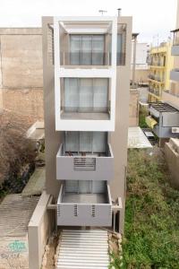 a building with threewindows and a staircase leading up to it at Cosy Luxury Apartment in Athens