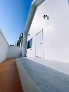 un edificio blanco con una puerta a un lado en Minimalism Pool Villa, en Thap Sakae