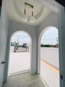 pasillo vacío con 2 puertas arqueadas y balcón en Minimalism Pool Villa, en Thap Sakae