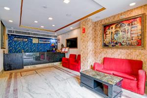 a living room with a red couch and a table at Raj Palace Near City Cetre 2 Taj Hotel in kolkata