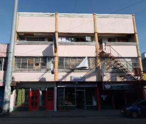 a tall building with a red door and a balcony at WJV INN BACOLOD in Bacolod