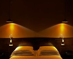 a bedroom with two beds with lights above it at Trastevere House in Rome