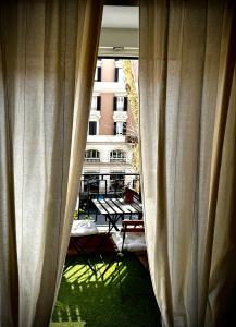 a view of a patio from a window with curtains at Trastevere House in Rome