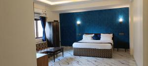 a hotel room with a bed and a blue wall at Royal Suites in Calangute