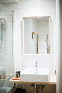 ein Badezimmer mit einem weißen Waschbecken und einem Spiegel in der Unterkunft Hostal Ses Negres in Begur