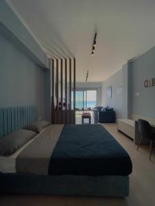 Charaki Sea Breeze Modern Studio with Balcony في شاراكي: غرفة نوم بسرير كبير وغرفة معيشة