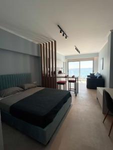 Charaki Sea Breeze Modern Studio with Balcony في شاراكي: غرفة نوم مع سرير وغرفة معيشة مع طاولة