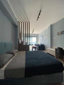 Charaki Escape Chic Studio with Seafront Patio في شاراكي: غرفة نوم بسرير كبير وغرفة معيشة