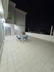 a table and chairs on a balcony at night at City center 1 bedroom apartment in Muscat