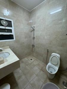 a bathroom with a toilet and a sink and a shower at City center 1 bedroom apartment in Muscat