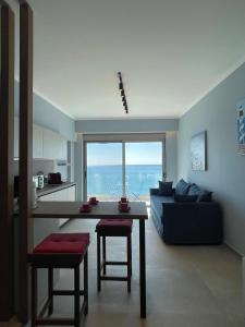 un soggiorno con tavolo e divano di Charaki Escape Chic Studio with Seafront Patio a Haraki