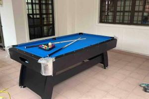 uma mesa de bilhar com dois tacos de bilhar em cima em Pelangi Indah 8 Rooms Corner Pool Table em Ulu Tiram