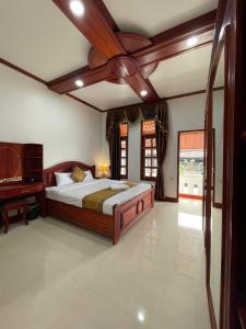 a bedroom with a bed with a ceiling fan at PhaiLin Hotel in Luang Prabang