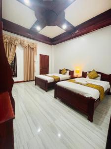 琅勃拉邦的住宿－PhaiLin Hotel，一间卧室配有两张床和吊扇