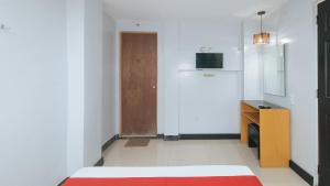 a room with a bed and a cabinet and a door at RedDoorz at Ranchotel Alabang in Manila