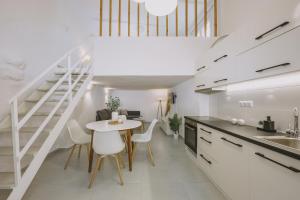 kuchnia ze stołem i krzesłami oraz schody w obiekcie ARGi House w mieście Maroulás