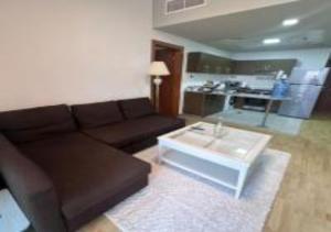 a living room with a brown couch and a coffee table at Key View - Binghatti Apartments in Dubai