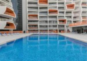 une grande piscine en face d'un bâtiment dans l'établissement Key View - Binghatti Apartments, à Dubaï