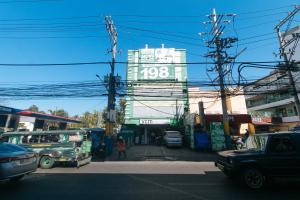 une rue de la ville avec un grand bâtiment en arrière-plan dans l'établissement RedDoorz at Ranchotel Alabang, à Manille