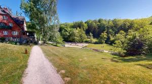 a dirt road next to a house and a grass field at Reiterpension Marlie in Scharbeutz