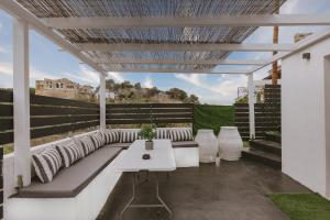 białe patio z białym stołem i krzesłami w obiekcie ARGi House w mieście Maroulás