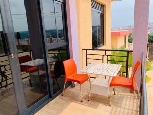 einen Balkon mit einem Tisch und Stühlen in der Unterkunft Exquisite Apartments- 1Bedroom Kigali in Kigali