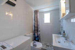 een witte badkamer met een toilet en een wastafel bij Alimos Marina Cozybase in Athene