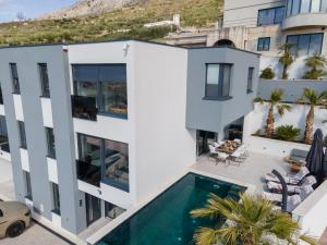 eine Luftaufnahme eines Hauses mit Swimmingpool in der Unterkunft Astonishing villa Blue Horizon w heated pool in Podstrana