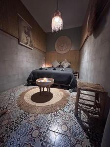 a room with a bed and a table on a floor at Douiria le pélican in Marrakech